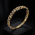 Studio display of the Elora Vine 18k gold bracelet featuring intricate diamond-studded leaf and vine patterns.