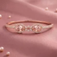 A studio product shot of the Embress wrap-style bracelet in 18k rose gold featuring two pear-cut peach-pink morganites and pavé diamonds on pink silk.