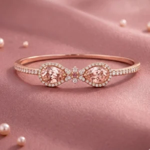 A studio product shot of the Embress wrap-style bracelet in 18k rose gold featuring two pear-cut peach-pink morganites and pavé diamonds on pink silk.