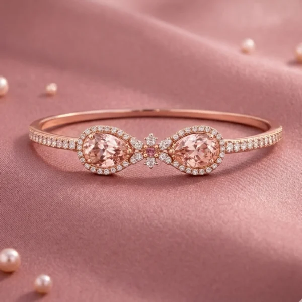 A studio product shot of the Embress wrap-style bracelet in 18k rose gold featuring two pear-cut peach-pink morganites and pavé diamonds on pink silk.