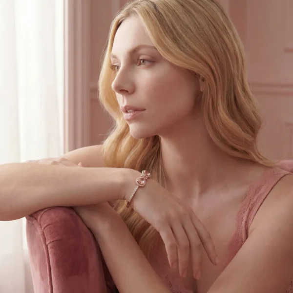A side view of a woman wearing the Embress wrap-style bracelet, showing how the rose gold and morganites hug the wrist.