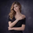 A woman in an elegant black off-the-shoulder dress wearing a luxury square-faced watch with a diamond bezel.