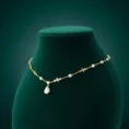 Gold Cleopatra necklace on green bust display
