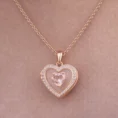 Closed rose gold heart locket featuring a pink center stone and crystal border.