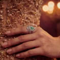 Detailed view of crown ring paired with gold sequin dress.