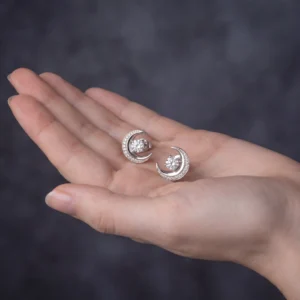 Hand holding crescent moon stud earrings