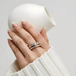 Ecliptia diamond rings displayed on hand with white knit