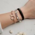 Person wearing white gold enchanted pearls bracelet with diamond accents