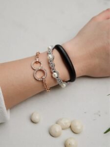 Person wearing white gold enchanted pearls bracelet with diamond accents