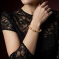 Delicate gold leaf bracelet with diamonds on woman in lace dress.