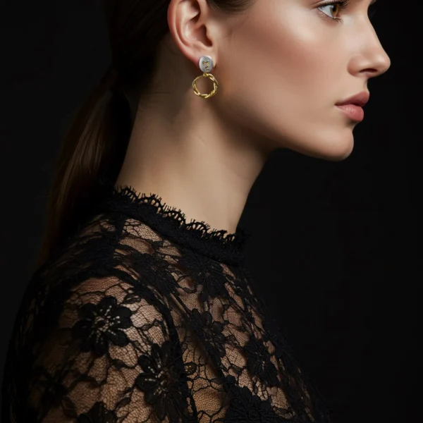 Side profile of a woman wearing Golden Twirl earrings with black lace.