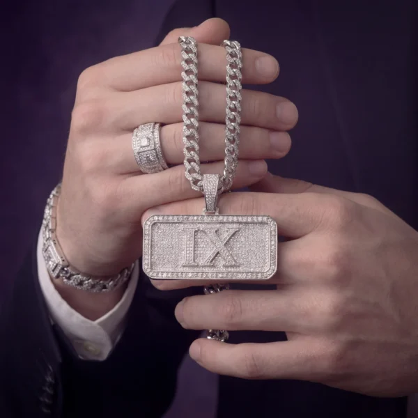 hand-held-monogram-pendant Hand holding iced-out IX pendant with silver cuban link