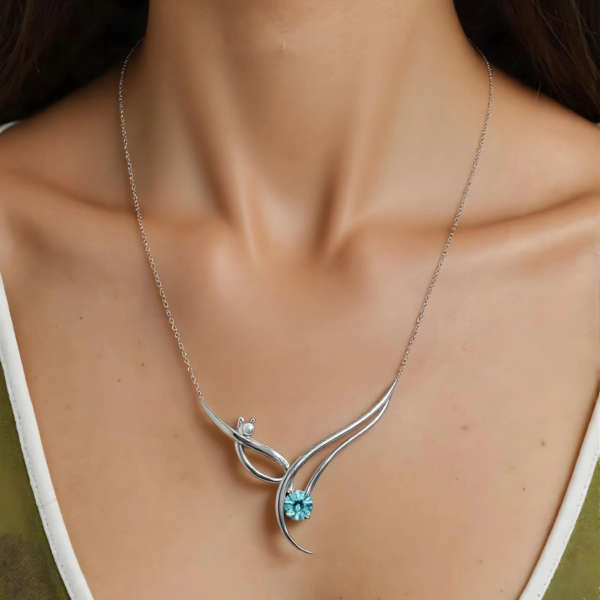 luminous-harmony-pendant Detailed view of the Luminous Harmony wave pendant with blue stone.