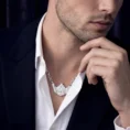 Man in white shirt and suit jacket with skyline necklace.