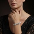 Woman in a black lace dress modeling the 18k white gold pearl and diamond bracelet.