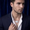 Man in navy blazer wearing diamond skyline necklace.