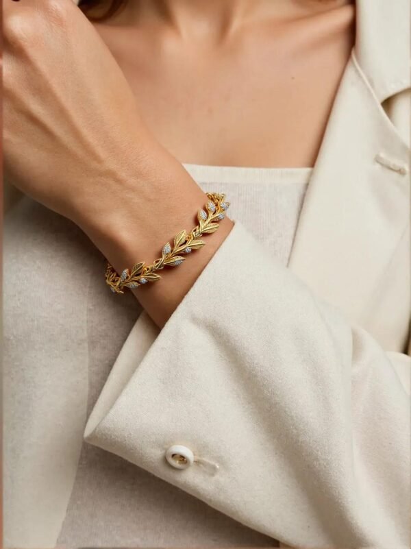 Woman wearing Naturaleza gold vine bracelet with white blazer.