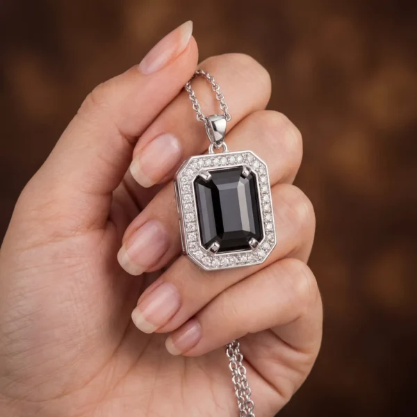 Noir Pendent jewelry held in hand to show size and detail.