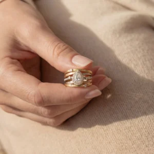 Person holding a Trinity Luxe mixed metal diamond ring.