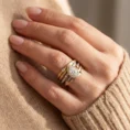 Close-up of layered Trinity Luxe rings on a finger.