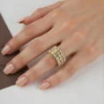 Close-up of Vera Forma wide gold diamond ring on a finger.