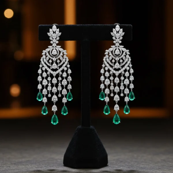 victorian-glow-emerald-earrings-display Silver Victorian Glow chandelier earrings with emerald accents on a black stand.