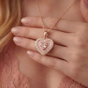 Close-up of a woman wearing a closed pink heart locket with rose gold accents.